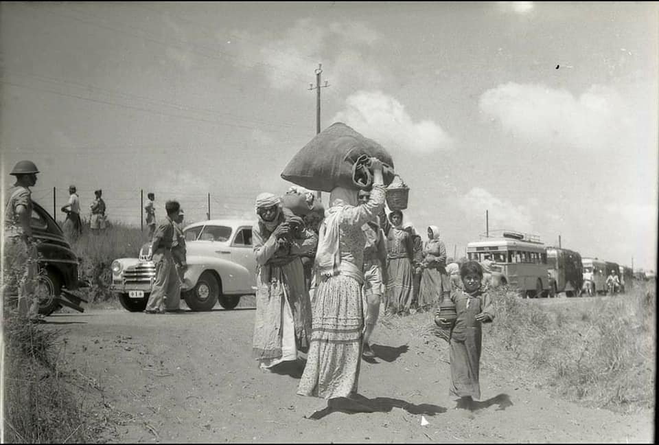 صورة لقرية الطنطورة - فلسطين: : More refugees (mostly women & children only) on their way out; ethnically cleansed out of their homes at al-Tantura. Please note the buses & red-cross cars, May 1948. Again all men were sent to labour camps; and 200+ of them were massacred soon after the village was occupied!